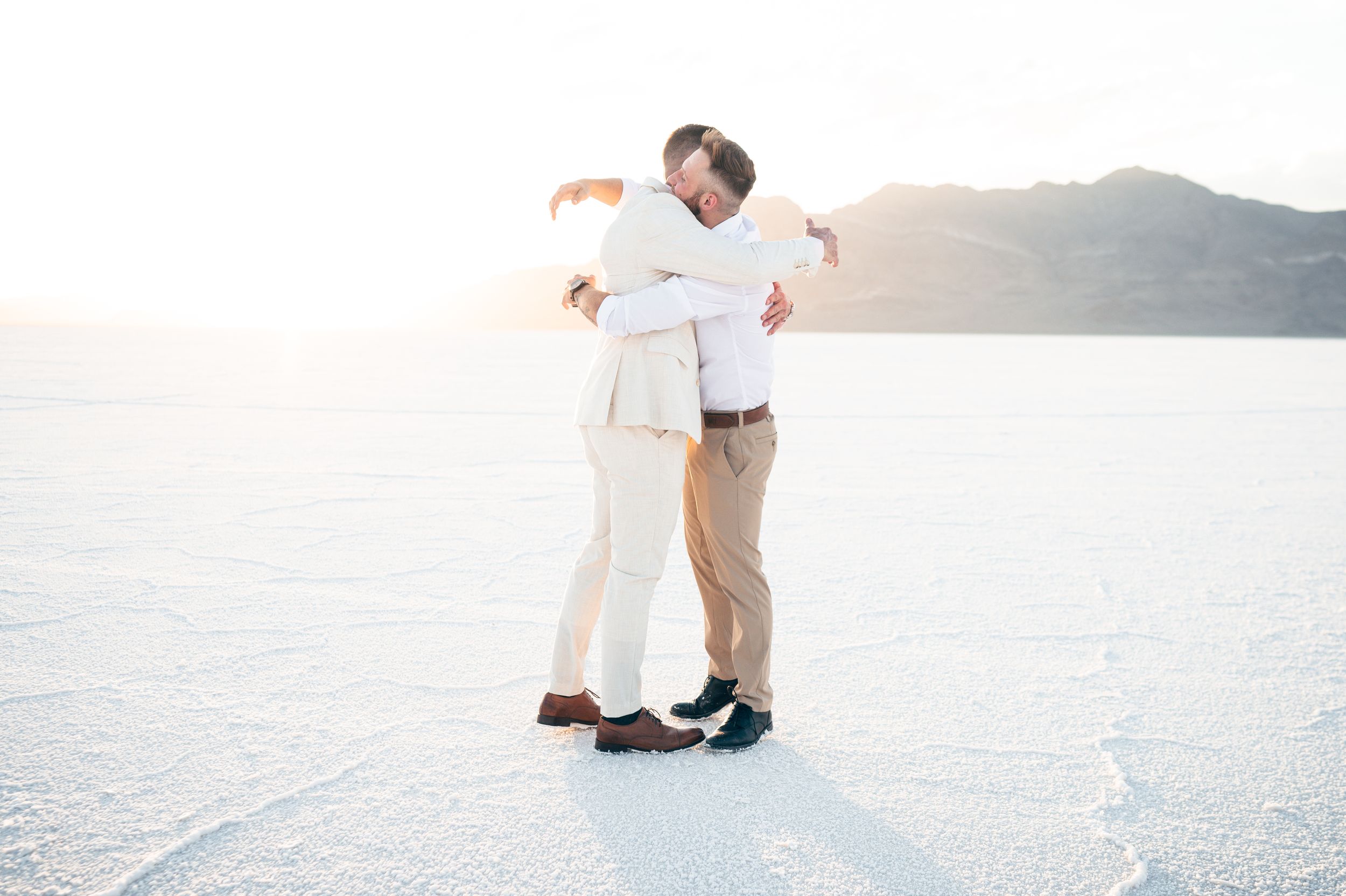 A small elopement on the salt flats with mountains in the distance at sunset. Salt flats elopement wedding photographer. Couples photography