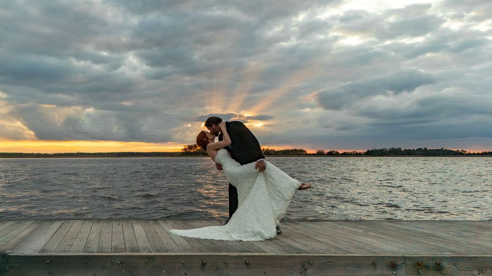 A panoramic collage of dramatic cloudy skies over a waterfront boardwalk at sunset.