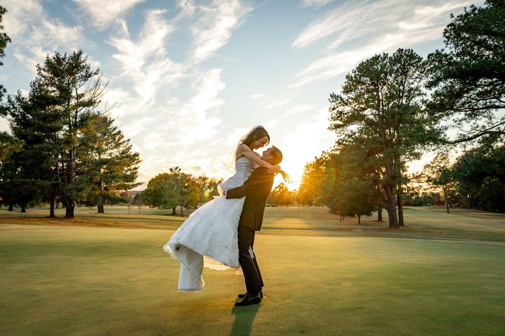 A romantic sunset photoshoot on a golf course with tall pine trees creating a dreamy silhouette against the golden sky.