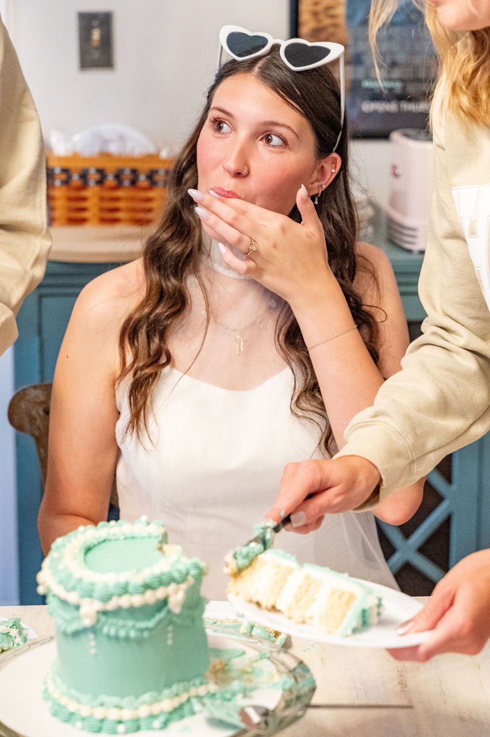 Group enjoying slices of mint green frosted cake at a celebration party.