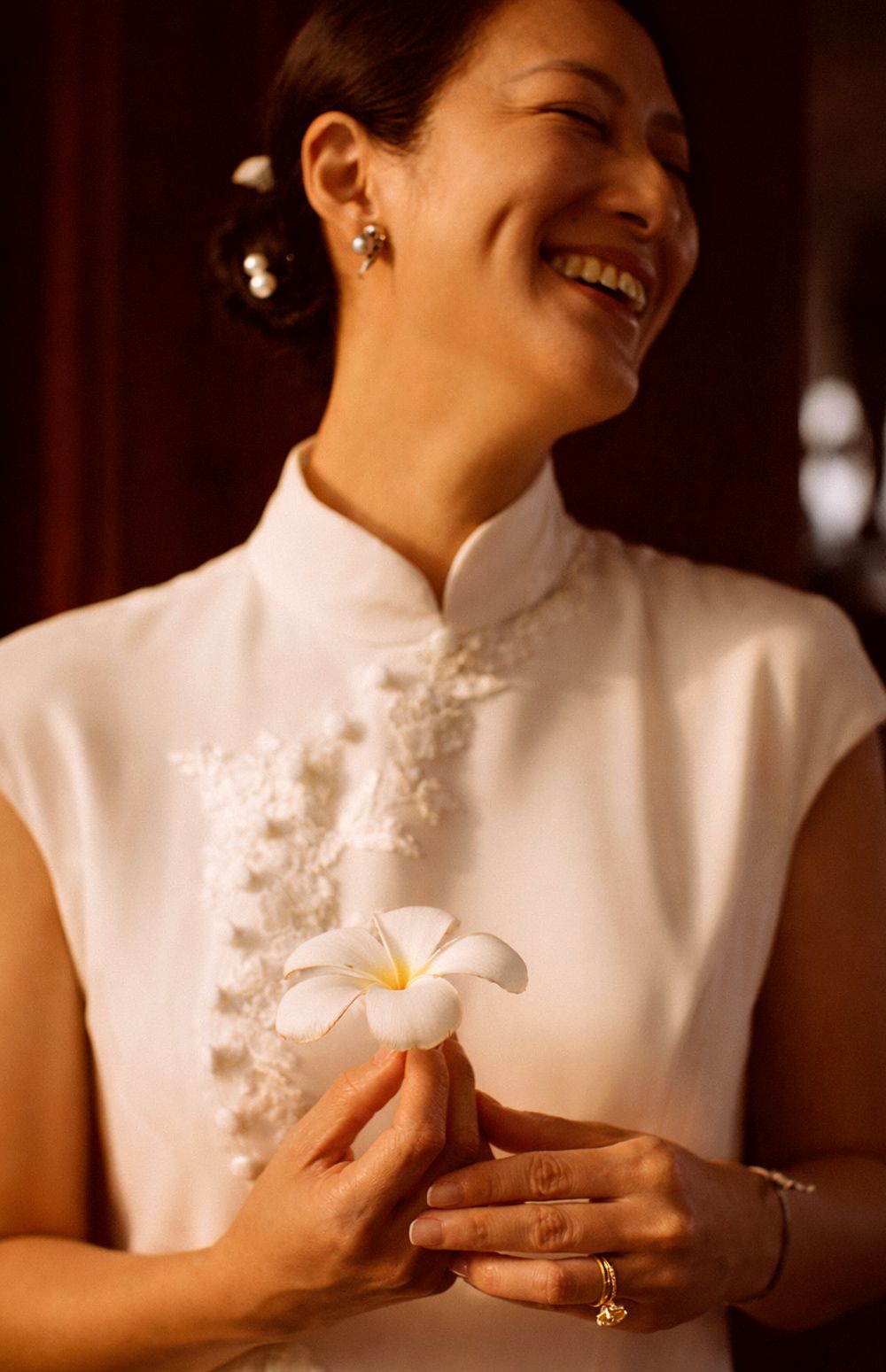chinese bride in elegant cheongsam at Intercontinental Koh Samui, warm light, intimate portrait and frangipani flower