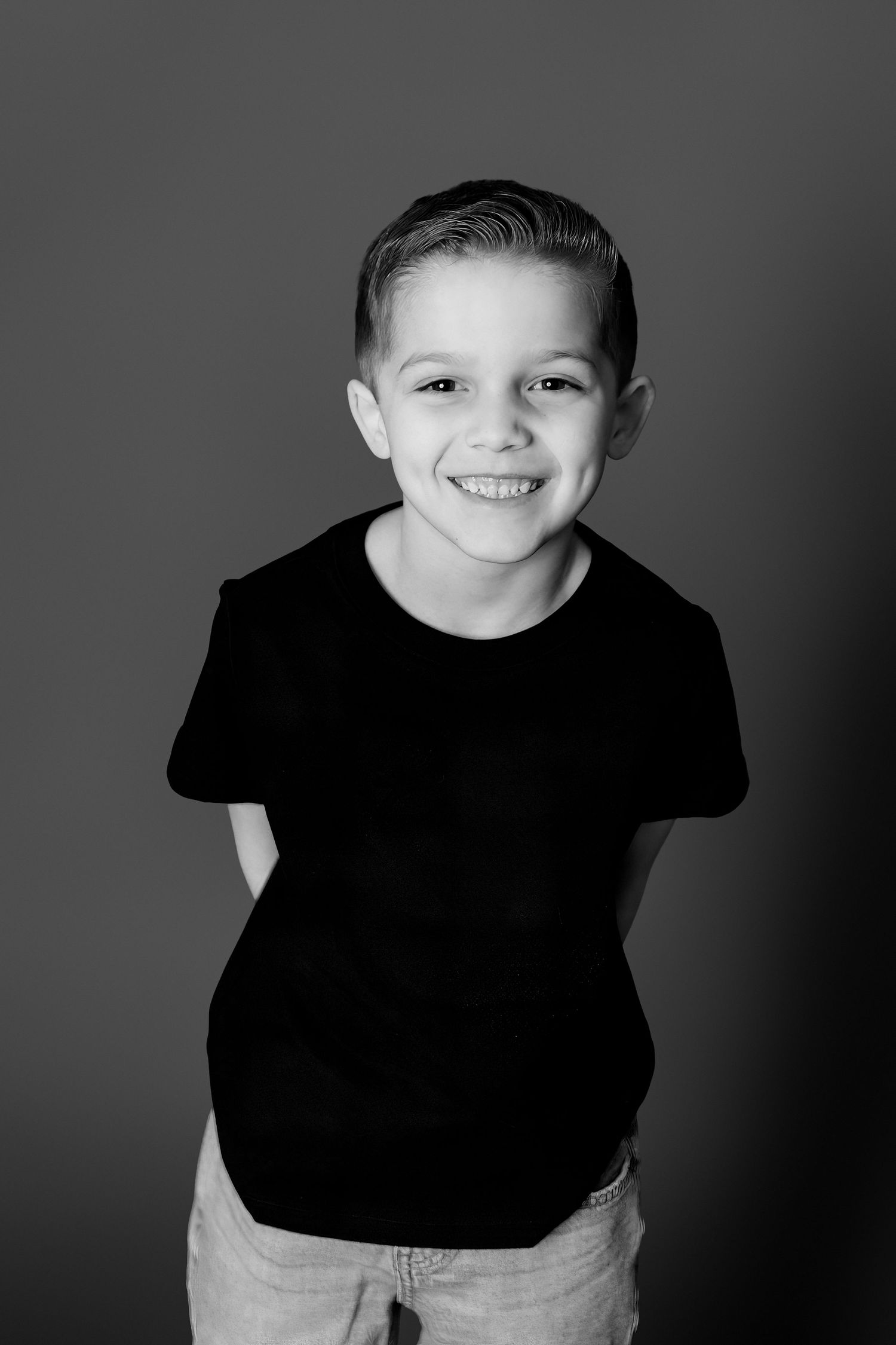A series of black and white portraits showing joyful expressions against a dark background.