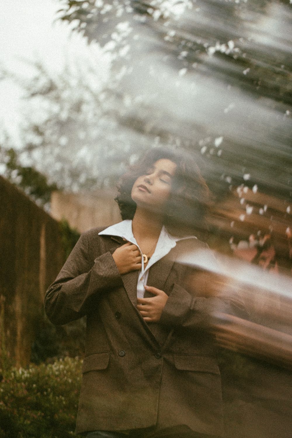A series of blurred motion photographs showing a person in a brown jacket with dreamy, ethereal lighting effects.