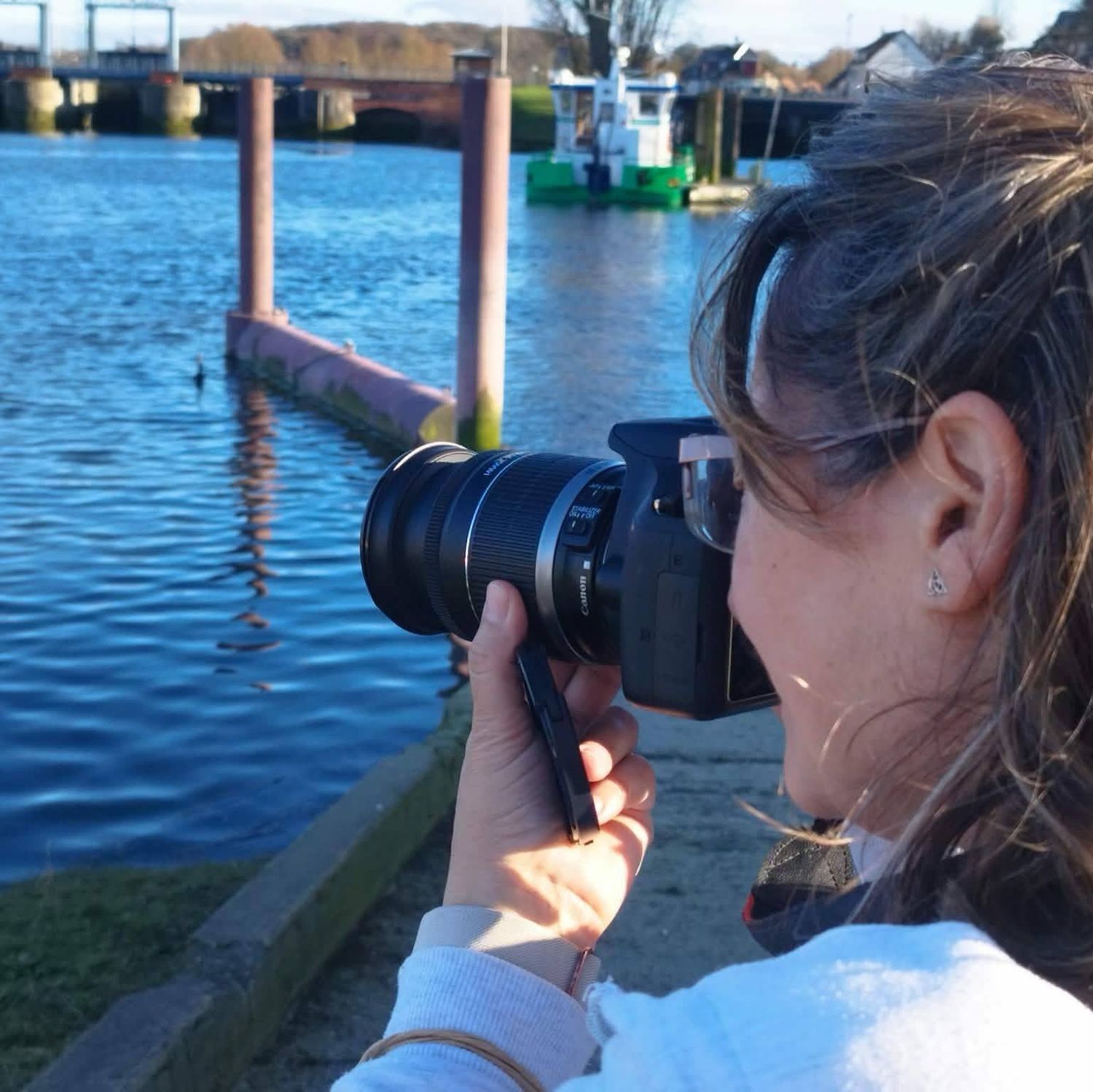 Photographe en train de capturer une image au bord de l’eau, Sandrine Photographie