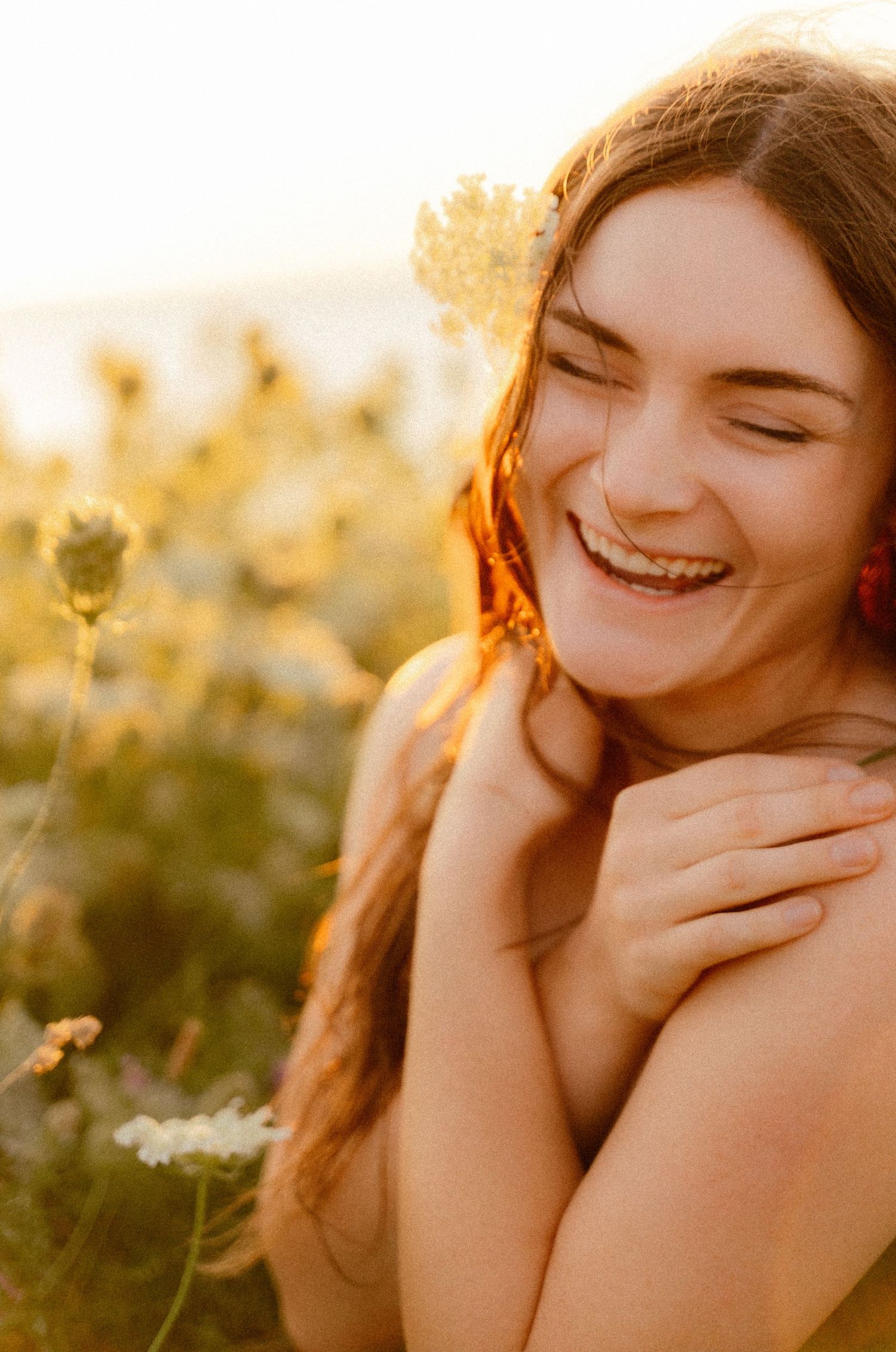 Joyful candid moment captured in golden sunlit flower field.
