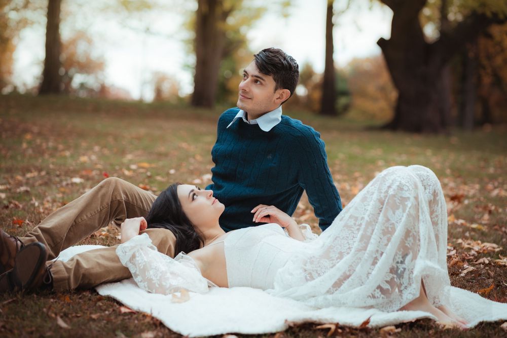 Couple relaxing together on a blanket during a fall engagement session.