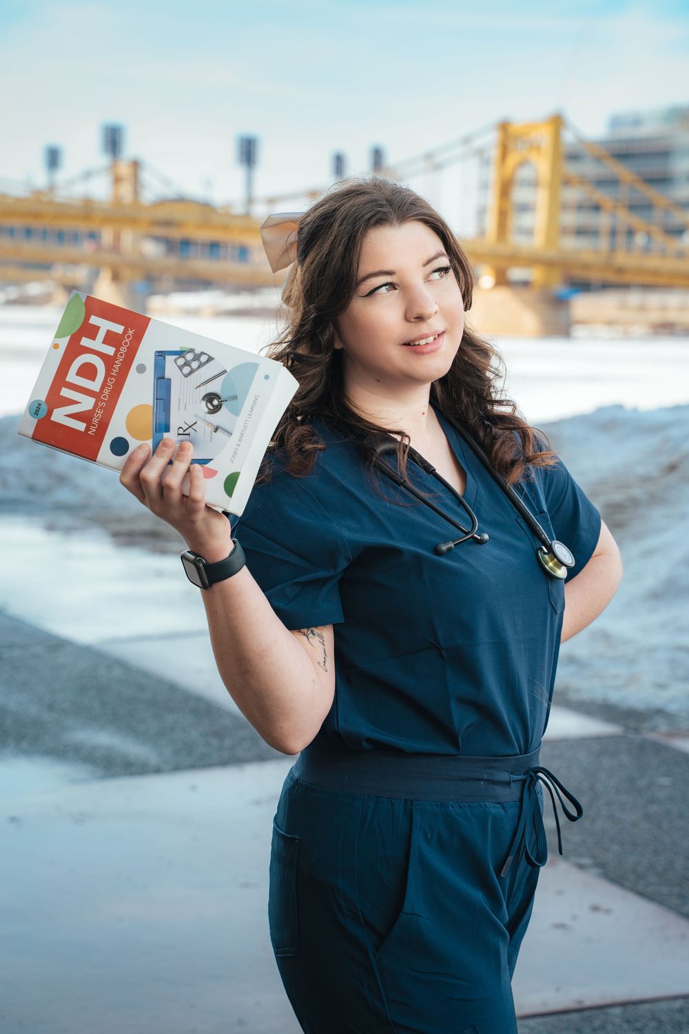 Medical school graduate posing with study materials in Pittsburgh.
