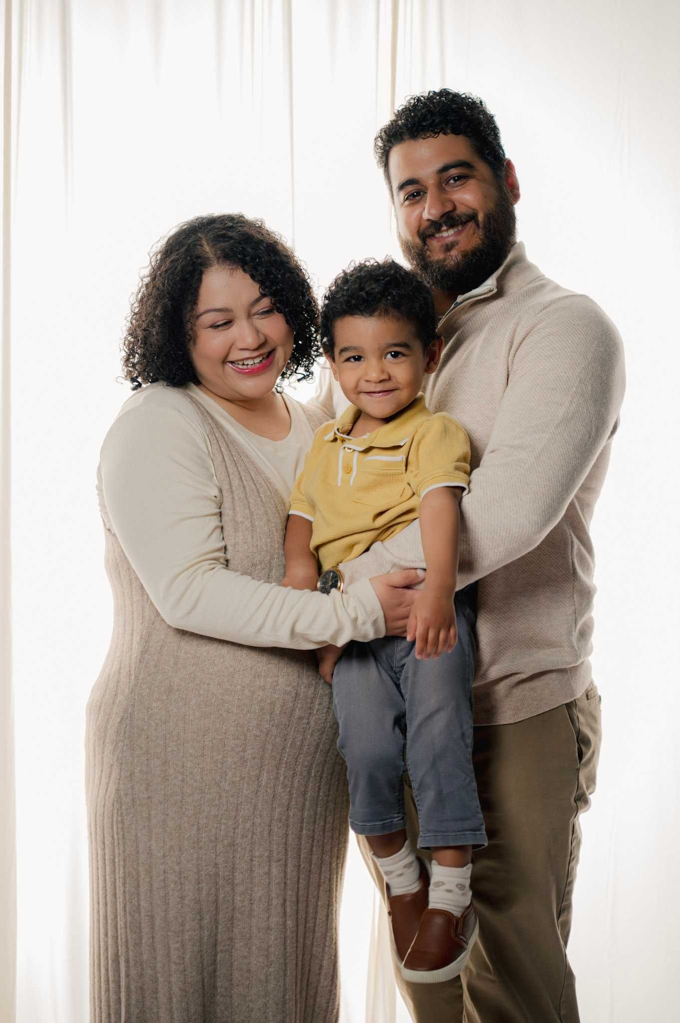 Family portrait series against white backdrop showing loving moments and warm embraces.