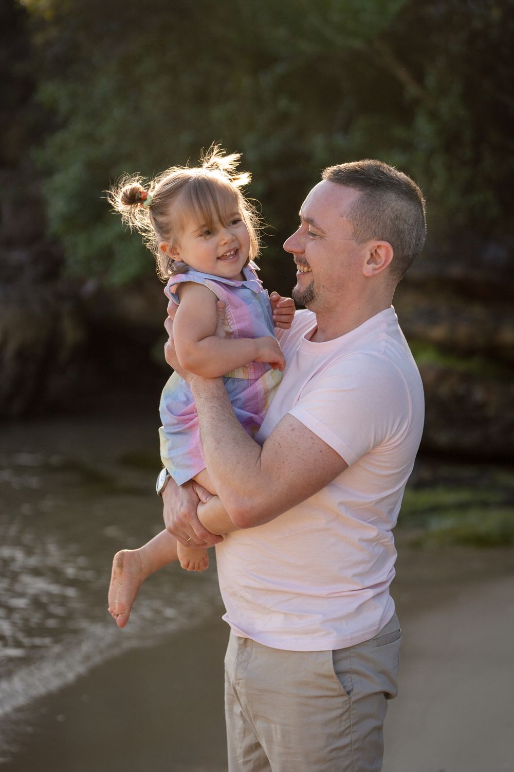 Dad and daughter cuddling during a family photoshoot at Manly, a sweet and loving moment between them