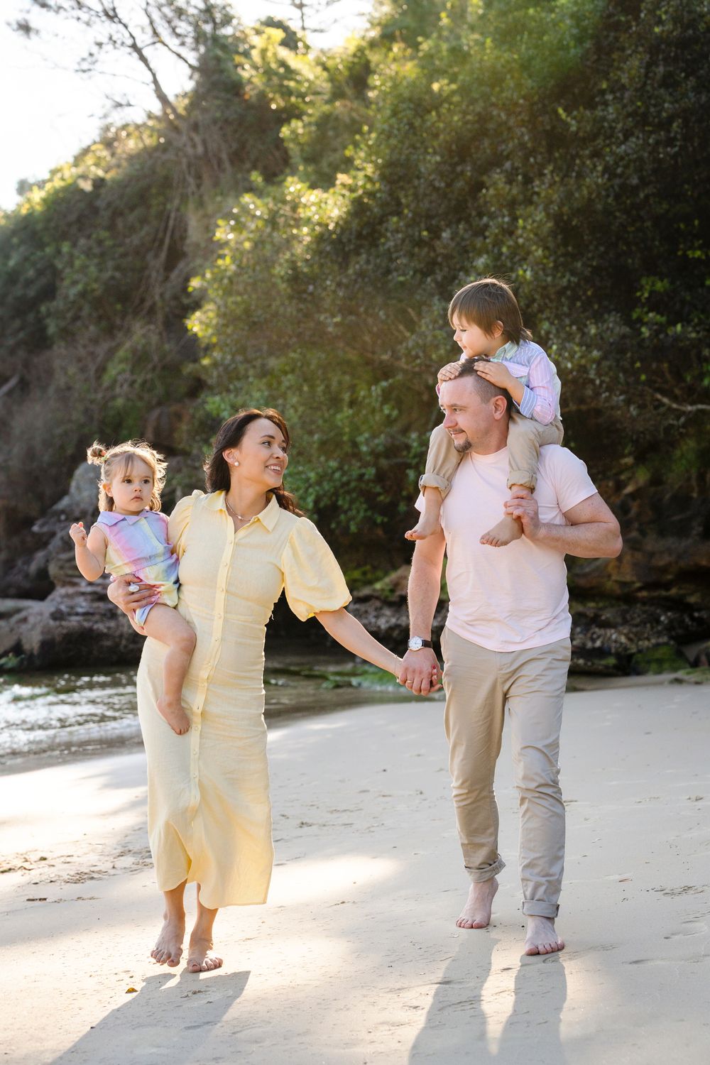 Family of four walking towards the camera at Collins Flat during golden hour family photoshoot