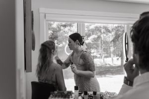 Getting ready scene with makeup being applied near a bright window.