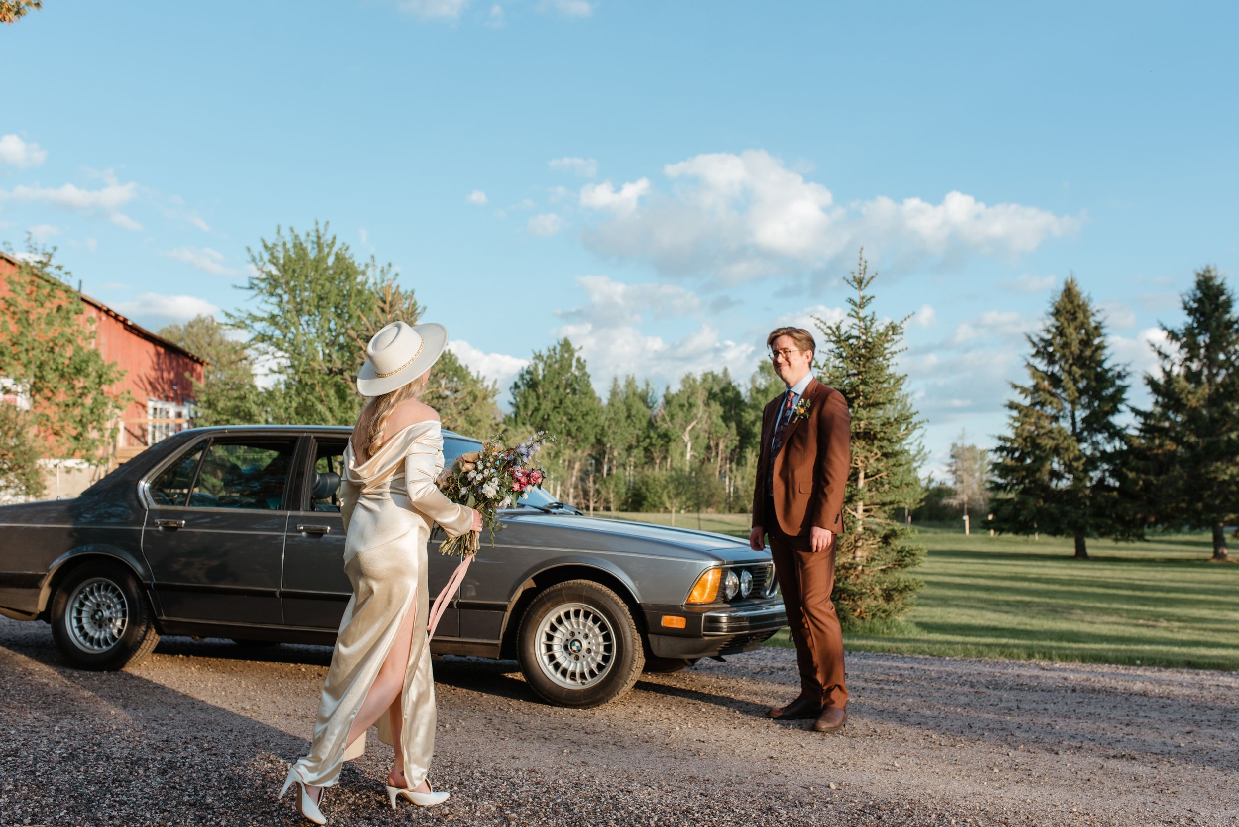 Vintage BMW adds classic elegance to outdoor wedding photography session.