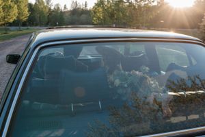 Sunlight streams through the windshield of a classic BMW during sunset.