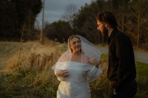 A couple sharing a joyful moment outdoors during their wedding photoshoot at golden hour.