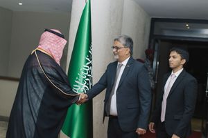 Saudi and Pakistani officials shake hands during a diplomatic meeting with Saudi flag in background.