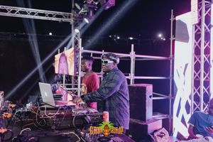 DJ performs at a nightclub with stage lighting and production equipment during a live electronic music event.
