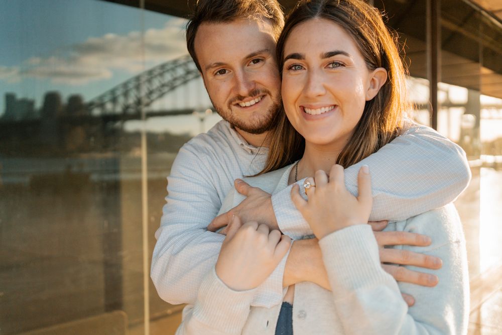 close up portrait of a couple with the Sydney opera house glass in the backdrop during a proposal photoshoot in sydney