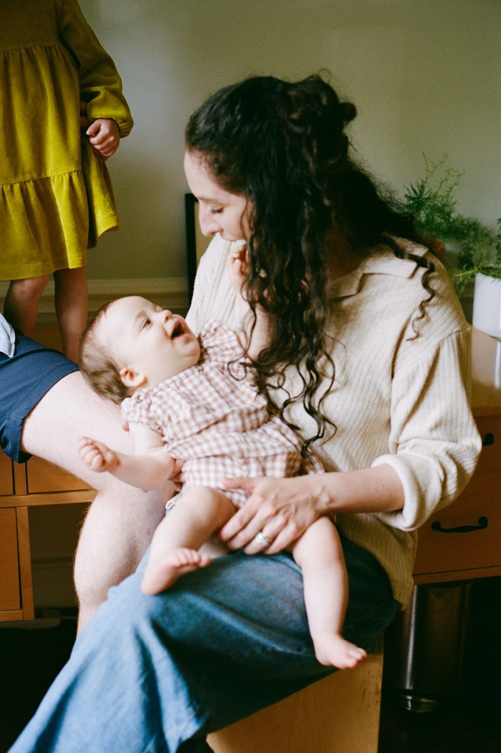 An intimate moment between parent and baby in casual indoor setting with natural lighting.