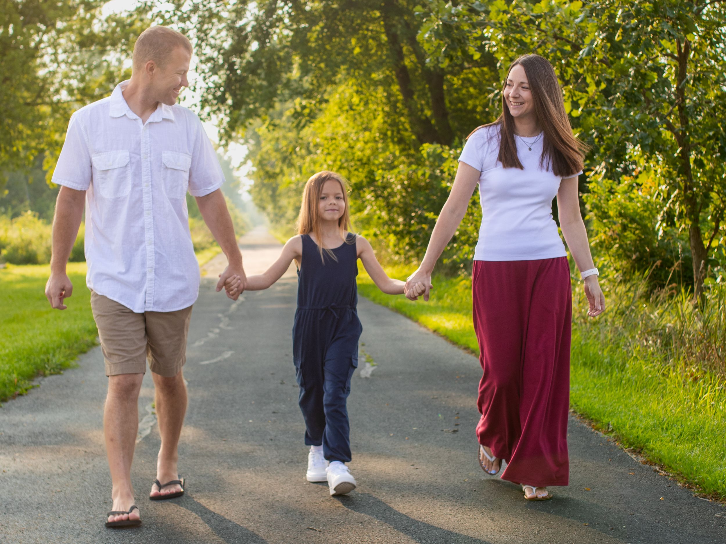 People walking together on a tree-lined path during golden hour.