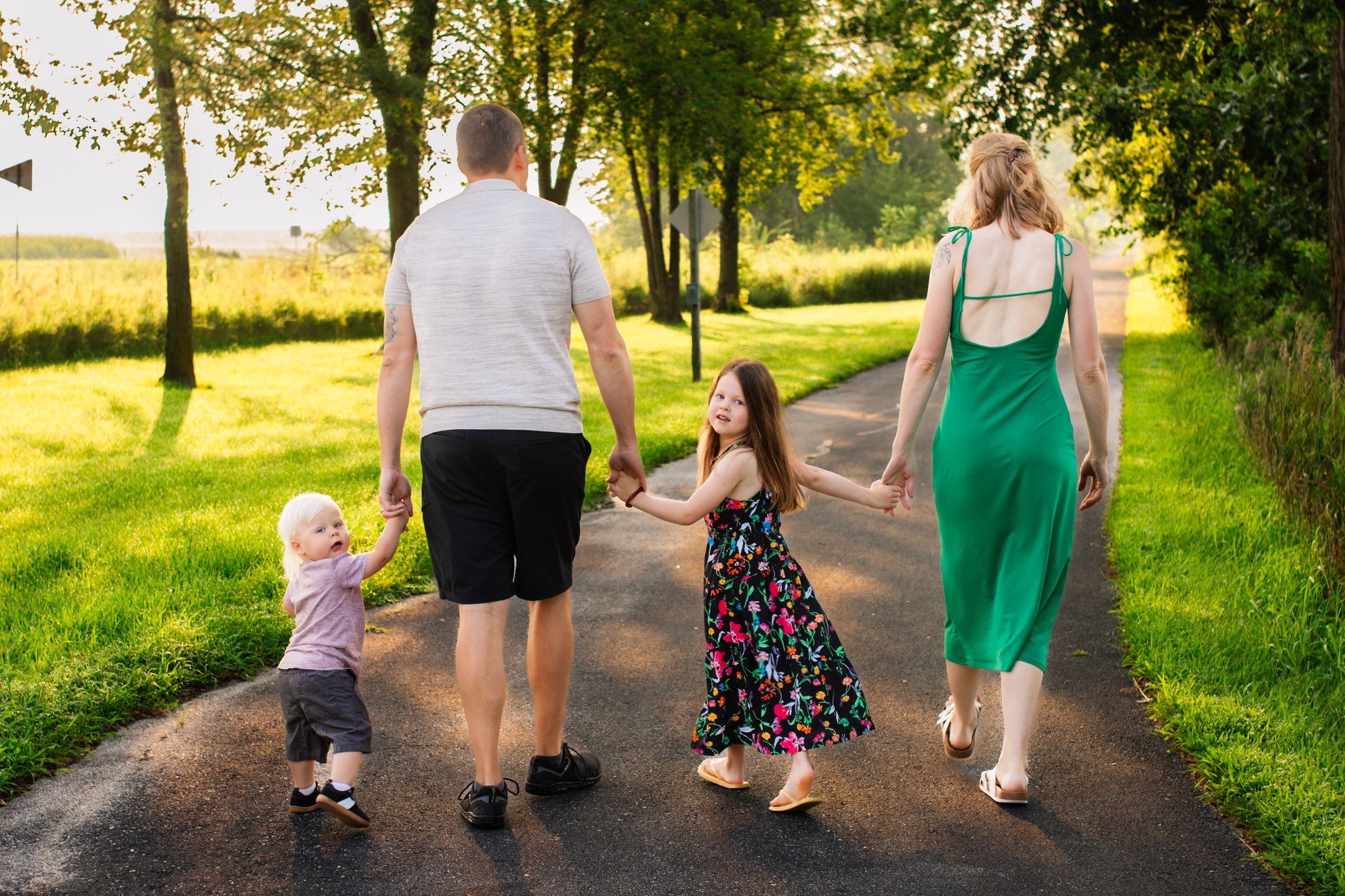 People walking together on a dirt path through green summer scenery.