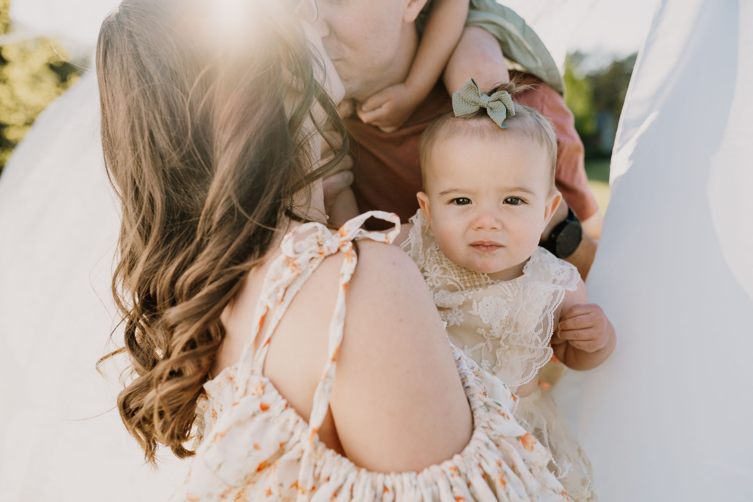 Little girl stares at the camera over her mom's shoulder during knoxville family photo shoot
