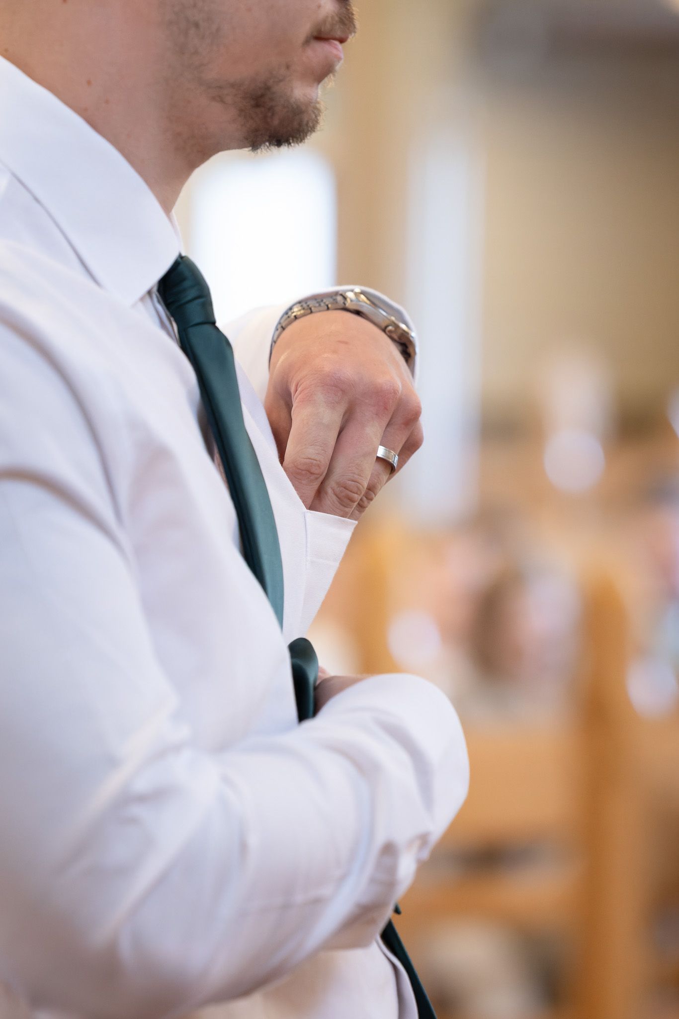 Close up view of a person wearing a white dress shirt and dark tie in a professional setting.