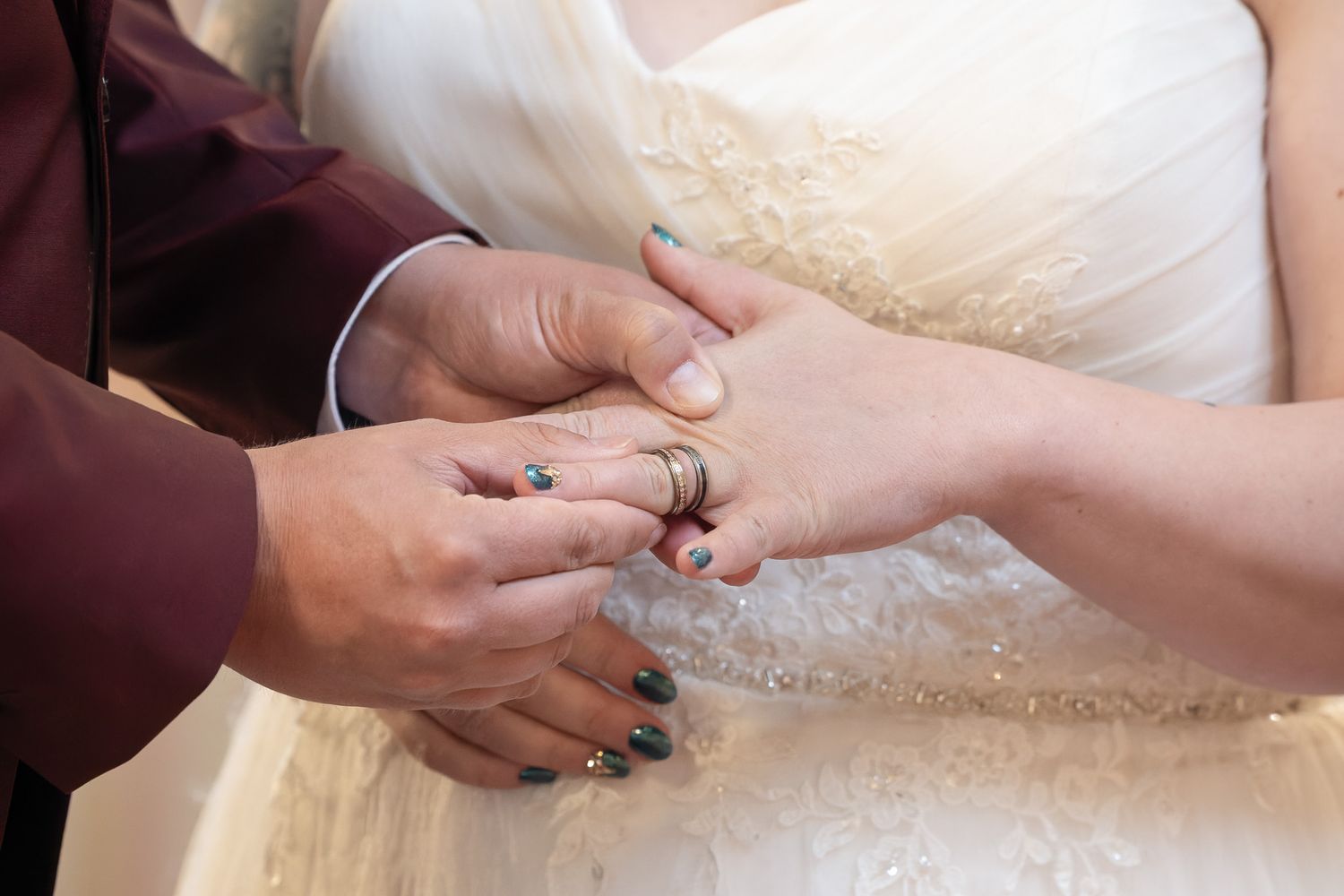 Close up of hands kneading and stretching raw pizza dough on a floured wooden surface.
