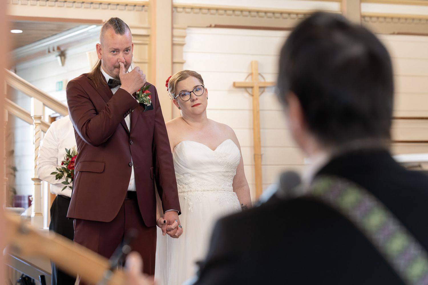 A bride and groom share a tender moment while walking together during their wedding ceremony.