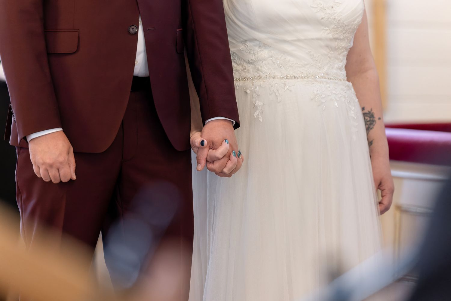 A group of wedding party members in formal attire stand together for a group photo.