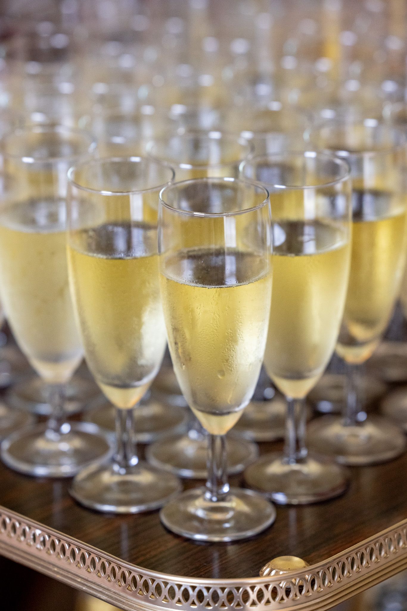 Elegant champagne flutes filled with sparkling wine arranged on a decorative silver tray for a celebration.