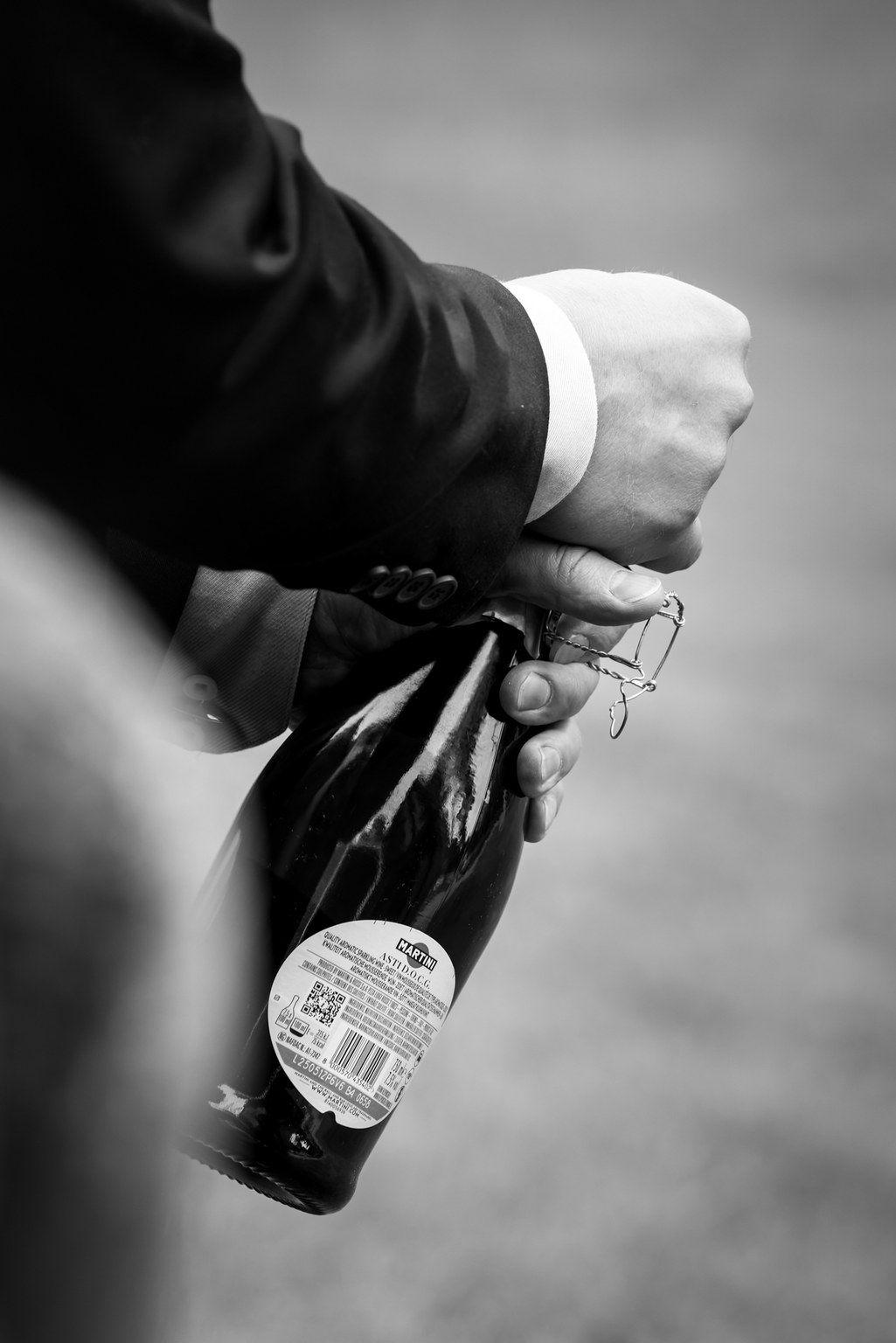 A sequence of black and white images showing hands opening a beer bottle in progressive stages.