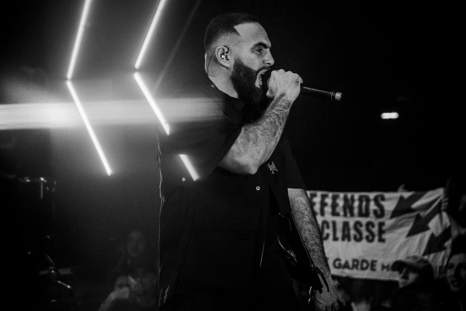 Artiste hip-hop en train de rapper, éclairage LED en forme de flèche en arrière-plan