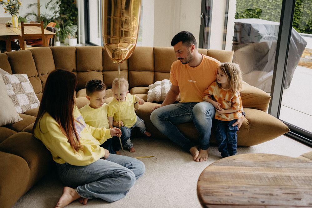 Family spending quality time together on a comfortable brown sectional sofa in a bright living room.