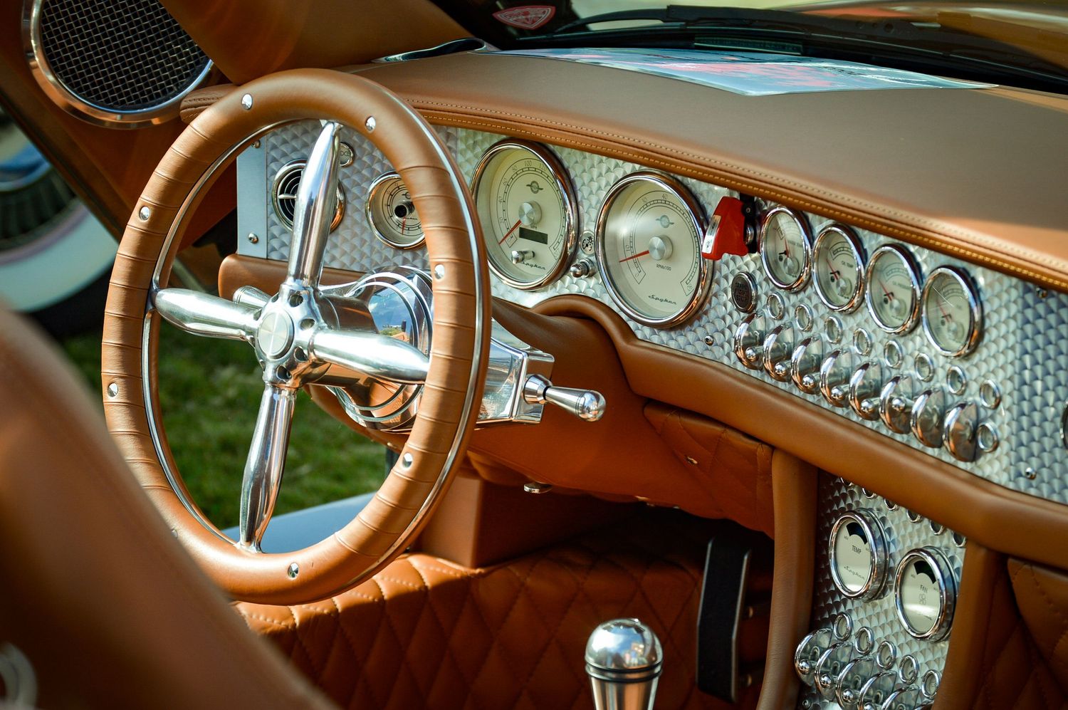 Luxury car interior featuring tan leather seats and modern dashboard design.