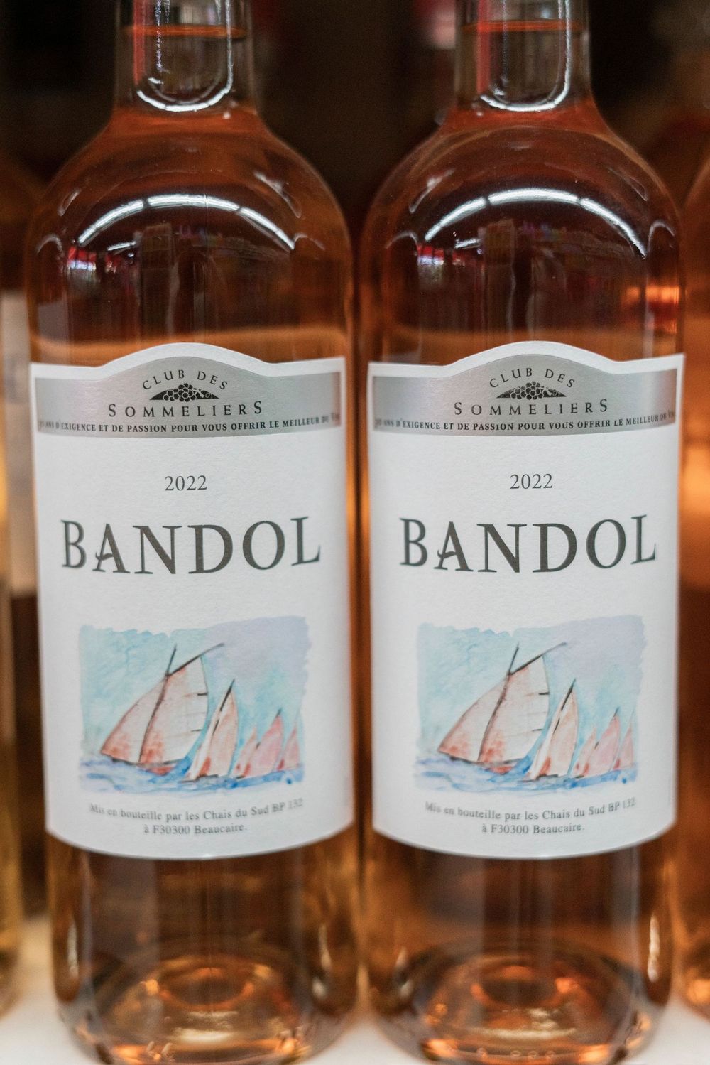 Two bottles of 2022 Bandol rose wine with sailing boat illustrations on their labels displayed side by side.