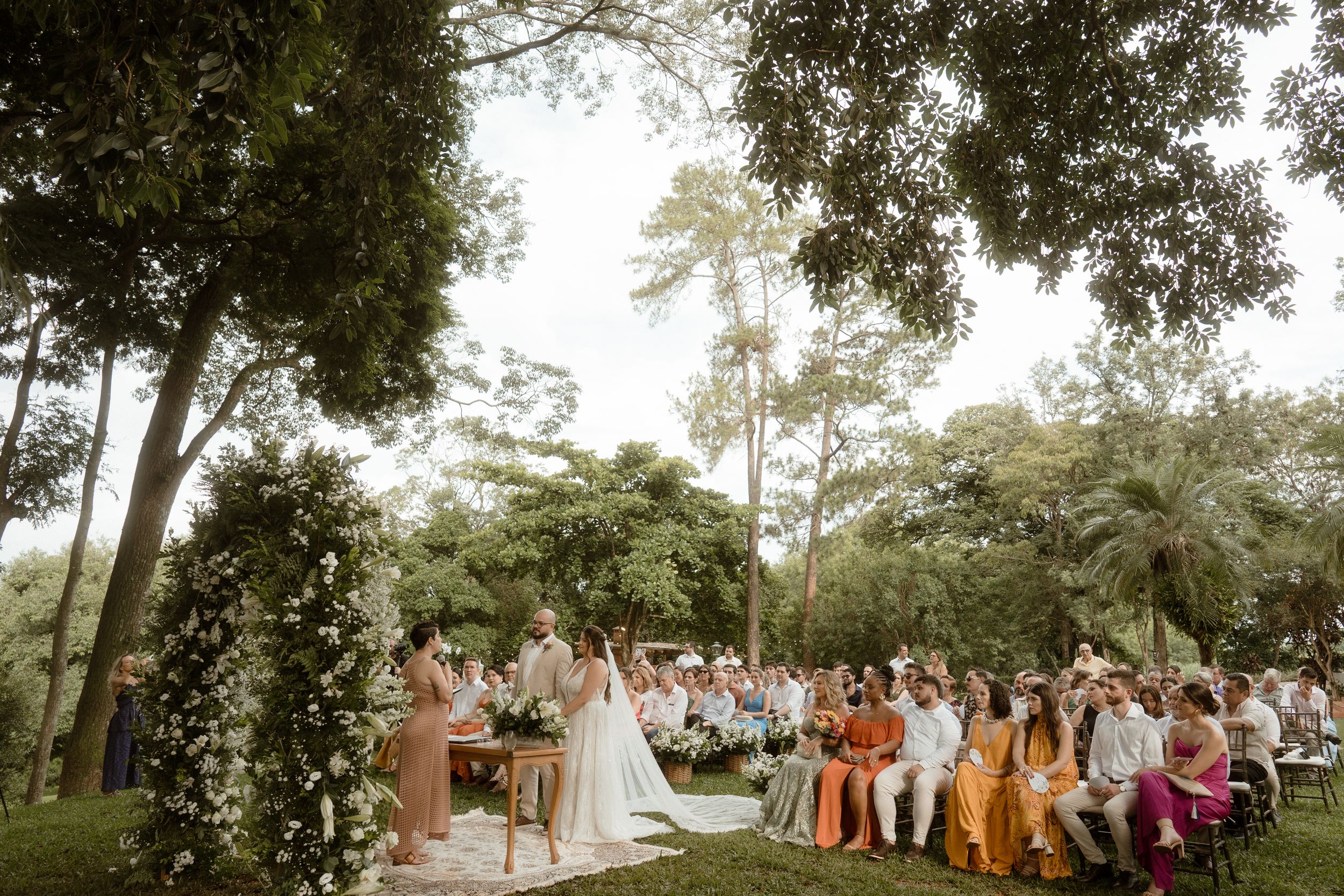 A beautiful outdoor wedding ceremony setup with rows of chairs and natural woodland backdrop.