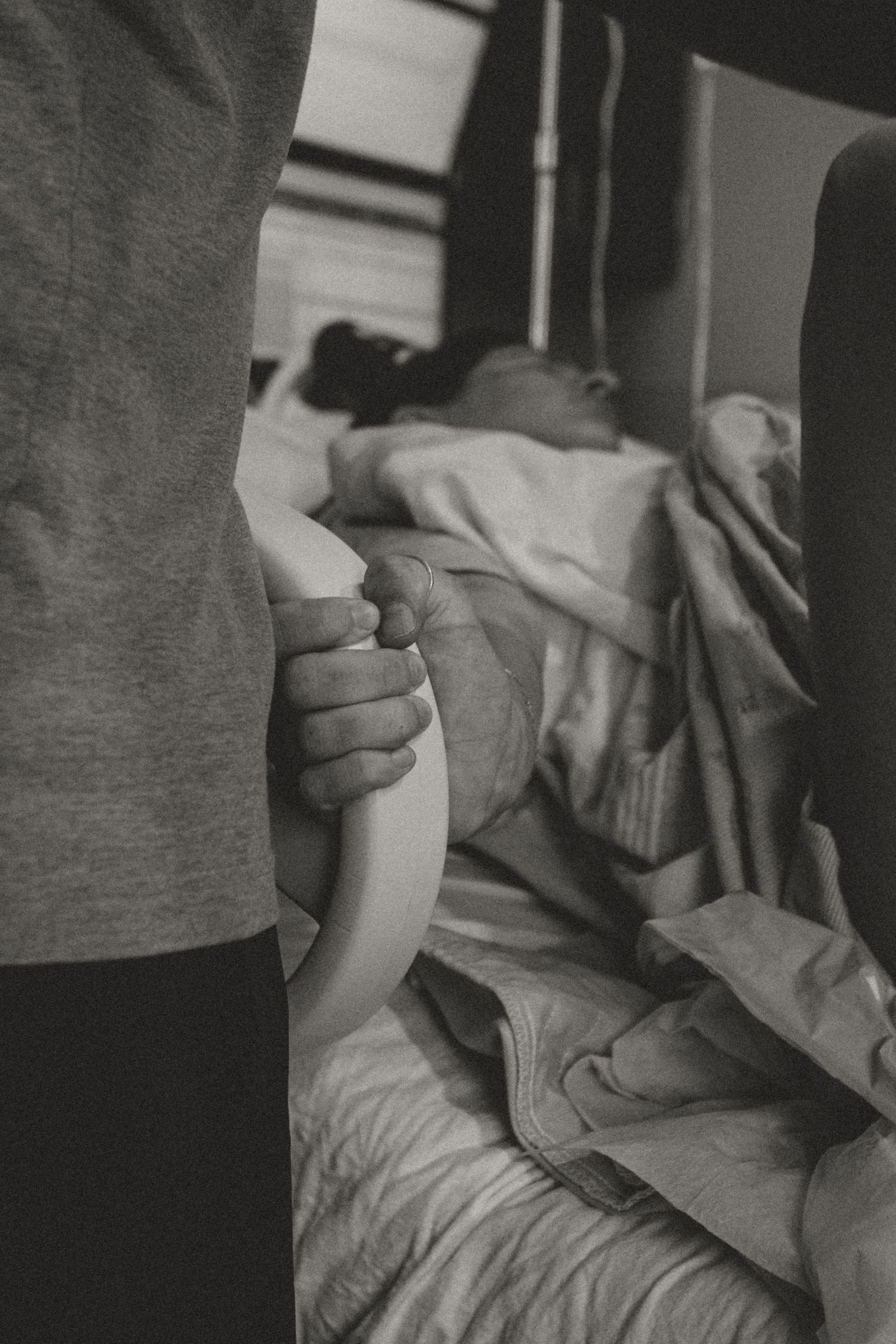 Close-up black and white image of hands holding a medical device or instrument.