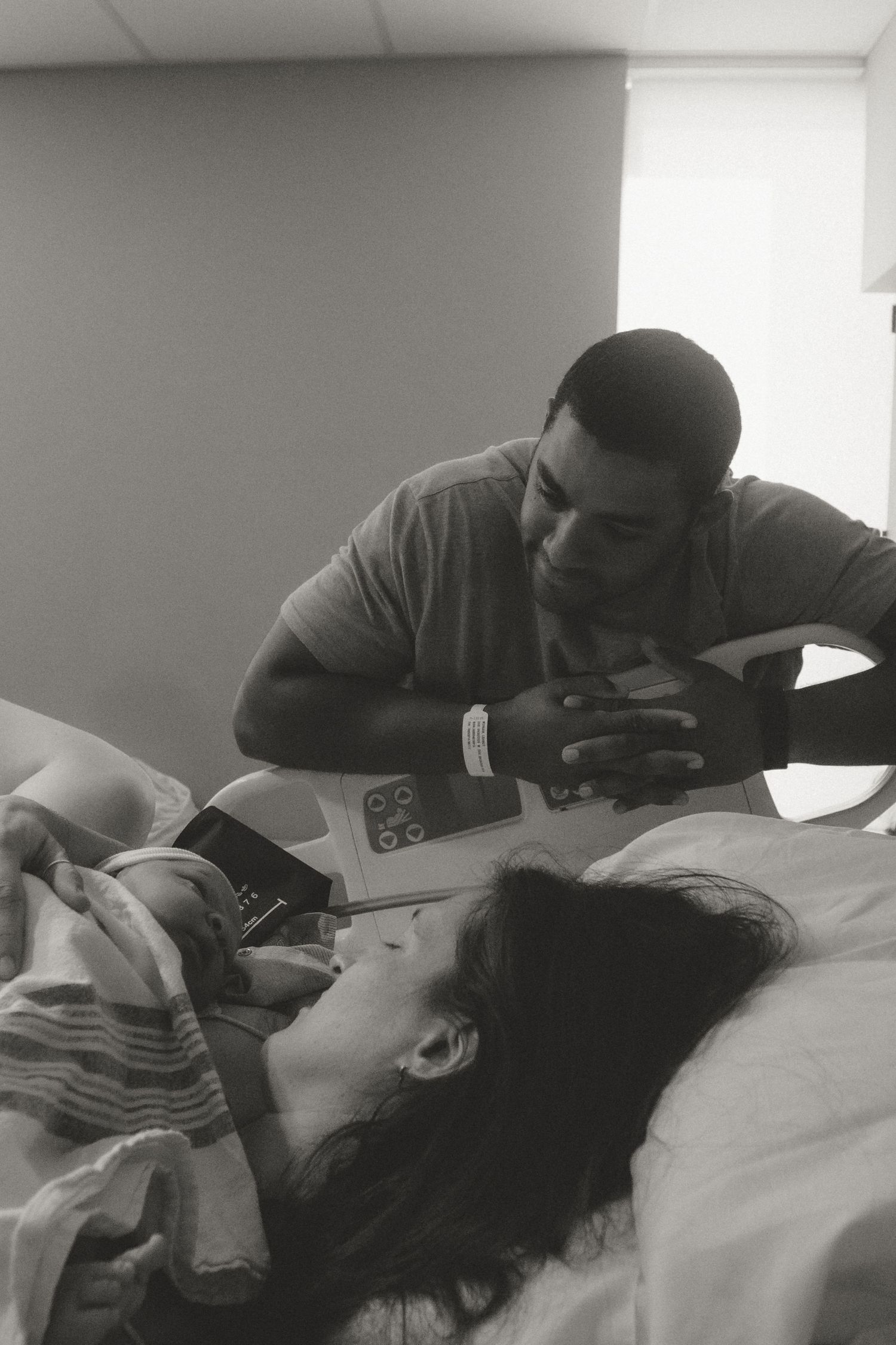 Black and white hospital photos showing tender moments between parent and newborn in a medical setting.