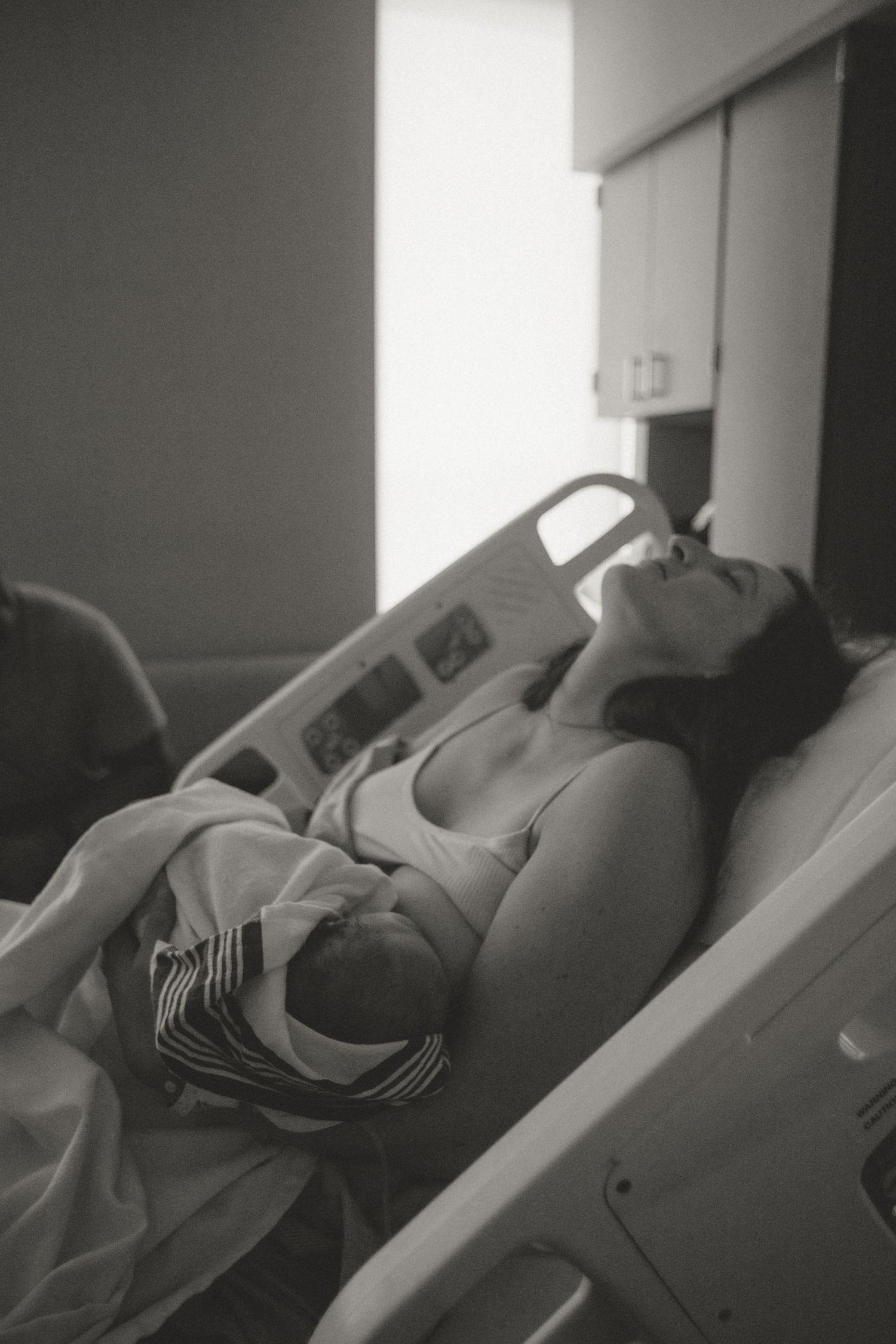 Side view of a patient resting in a hospital bed with medical equipment visible.