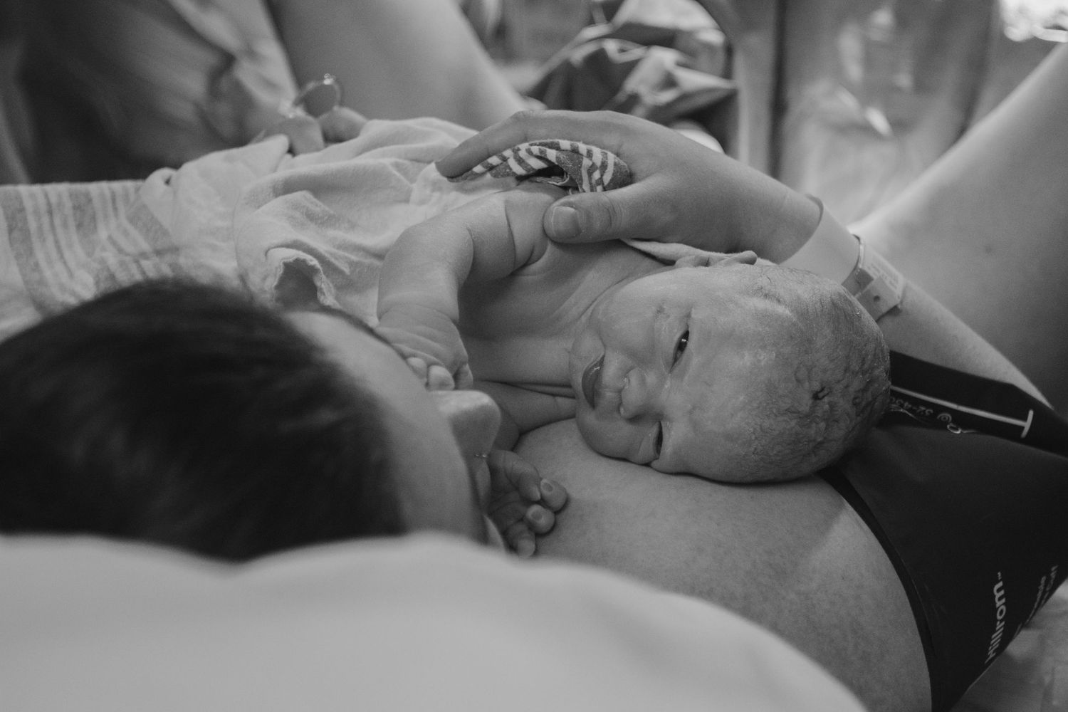 Black and white photo series showing various tender moments between a parent and newborn baby in hospital.