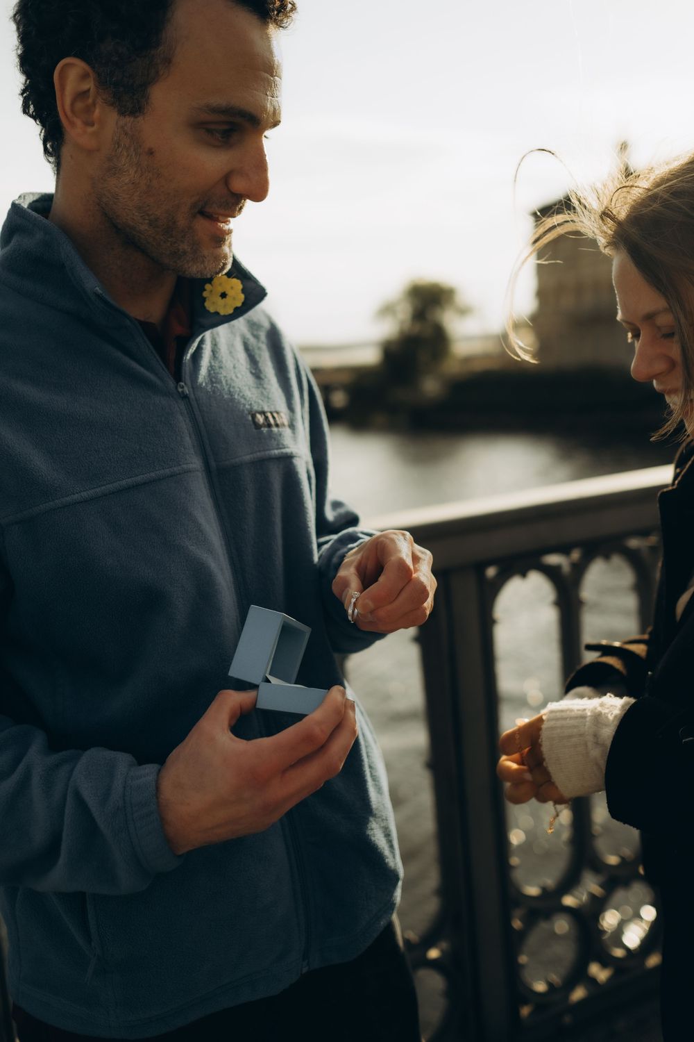 man taking an engagement ring out of a box during surprise proposal in Stockholm