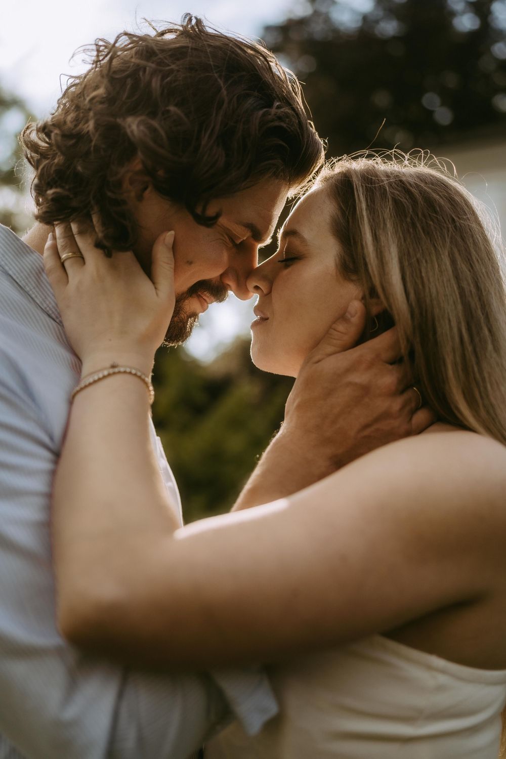 An intimate romantic moment captured between a couple in warm natural lighting.