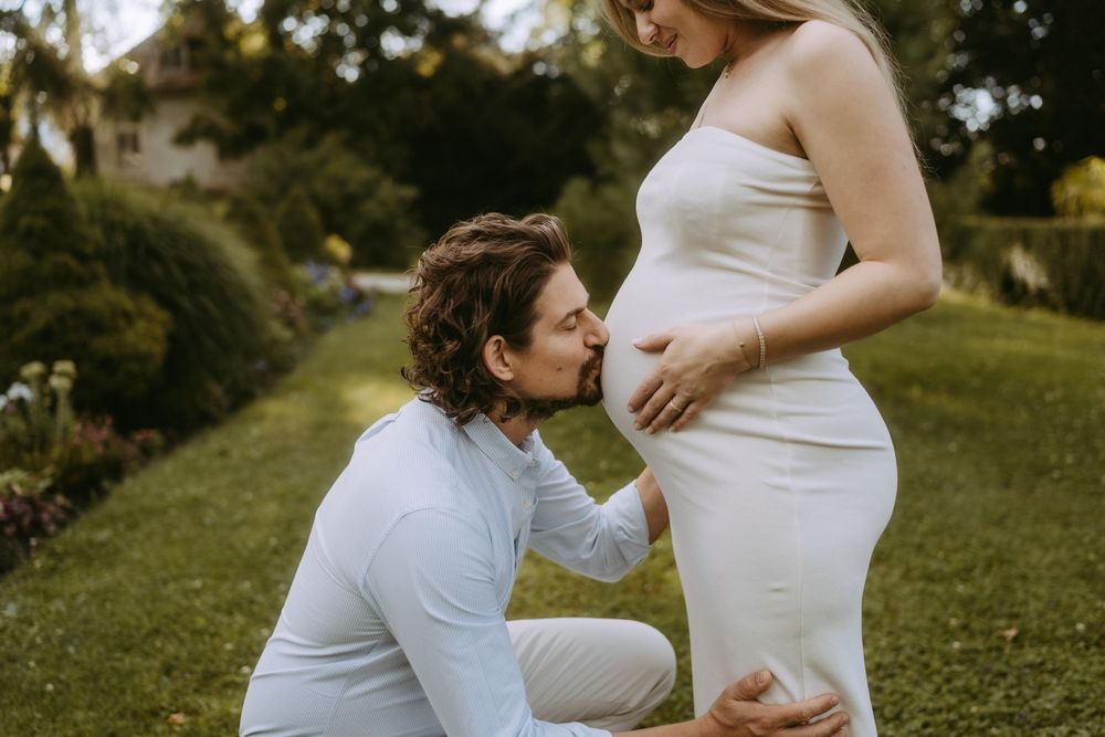 A maternity photo showing tender moments between expectant parents outdoors.