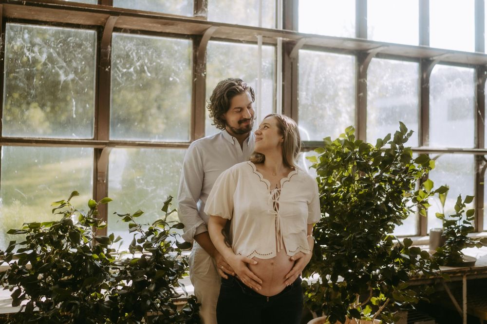 Romantic greenhouse photoshoot with abundant greenery and natural lighting.