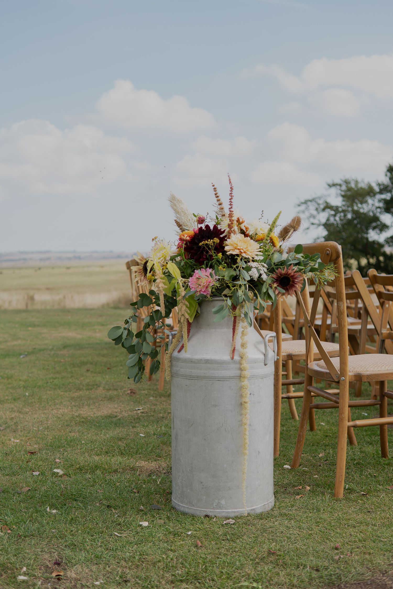 Beautiful milk churn floral display at an outside wedding in Kent | Flowers created by BLOOM Fabulous | Flowers grown in Kent