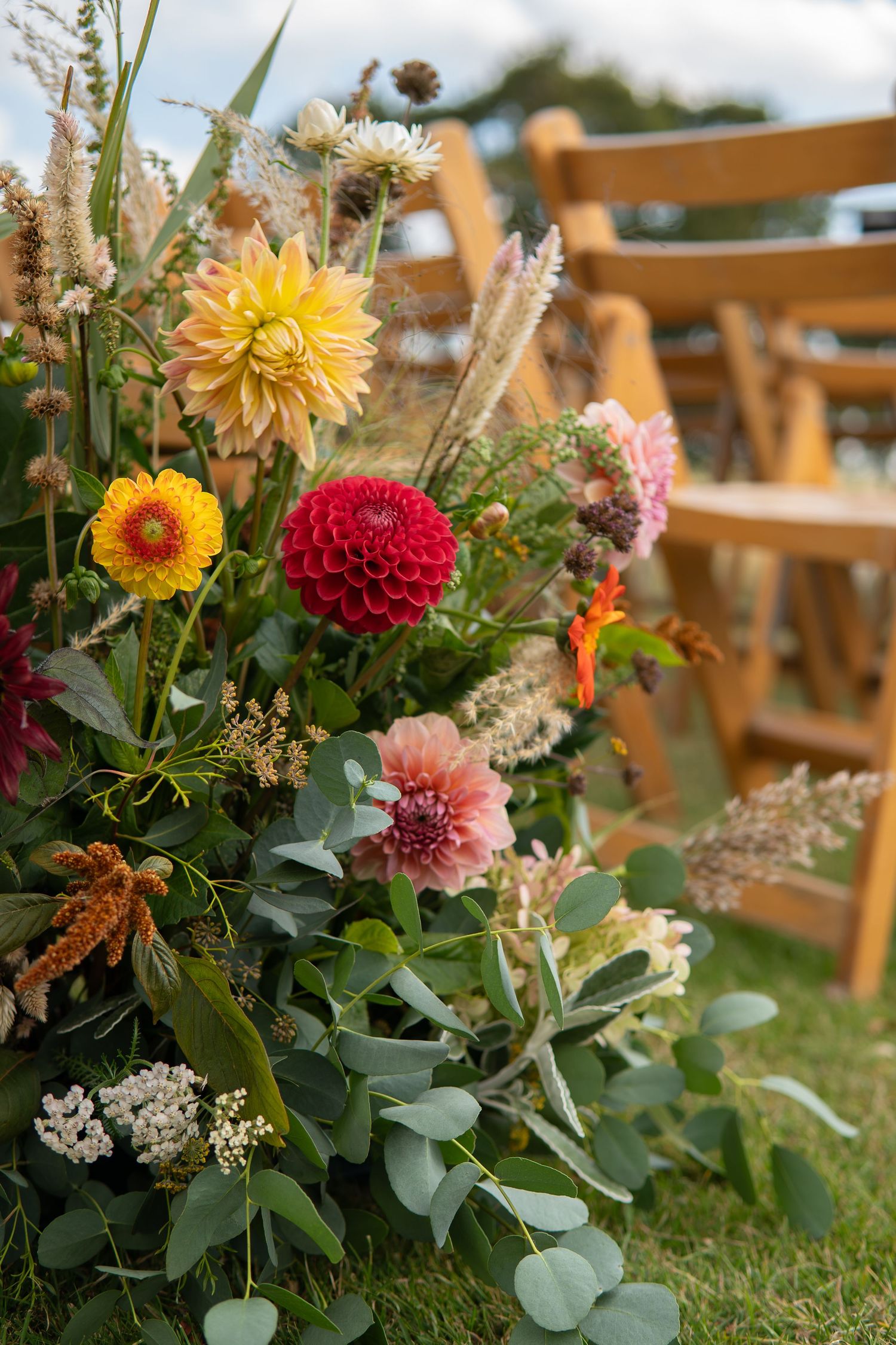 Stunning wild & natural meadow boxes lining rows of chairs at an outdoor wedding | Flowers created by BLOOM Fabulous | Flowers grown in Kent