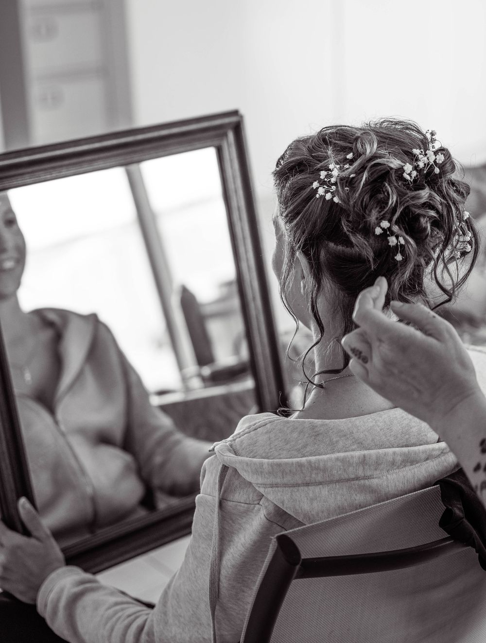 A person getting their hair styled and arranged with decorative pins in a salon setting, shown in multiple angles.