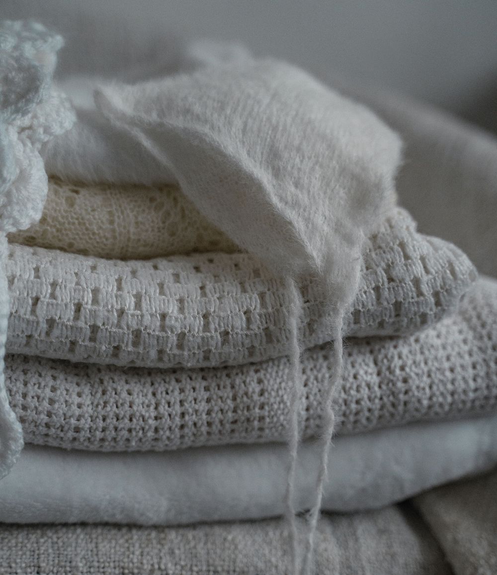 Earthy-toned knitted blankets and baby clothes prepared for a lifestyle photography session in Derbyshire and beyond.