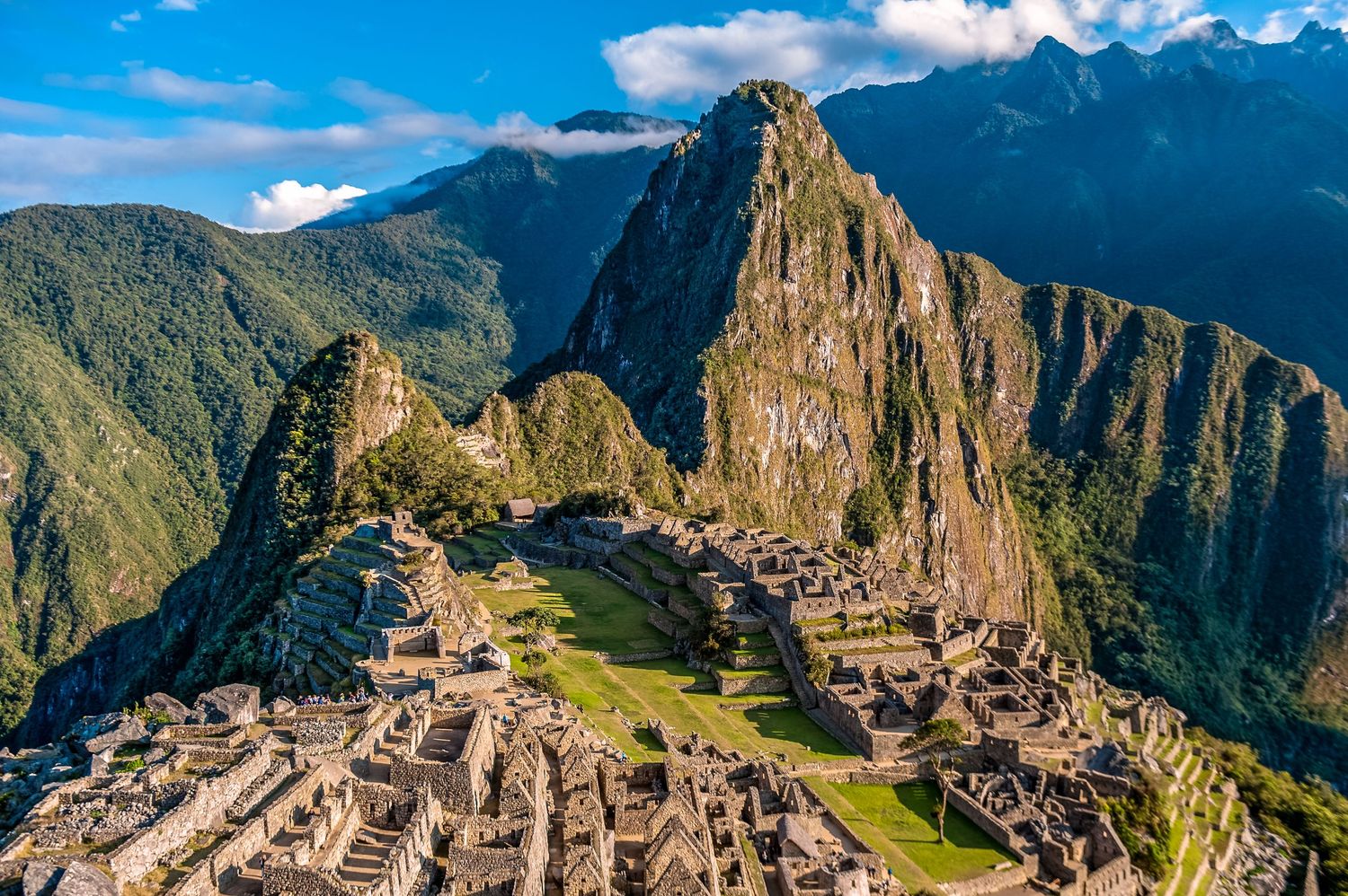 Ancient stone ruins of Machu Picchu nestled in the Andes Mountains with dramatic peaks and green valleys in Peru.
