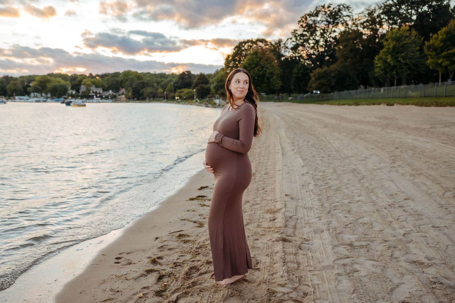 A series of maternity photos taken on a sandy beach at sunset with soft golden lighting and ocean waves.